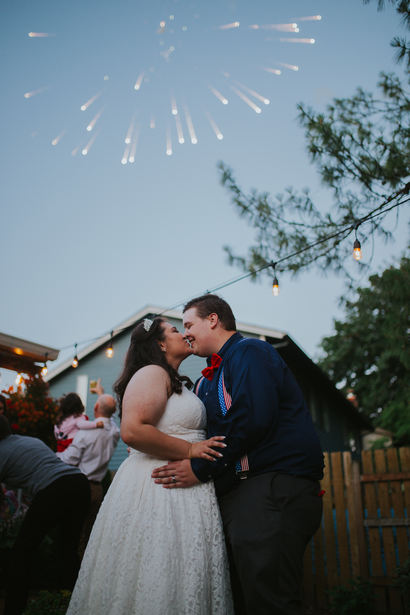 Bride and Groom kissing underneath Fireworks while dancing